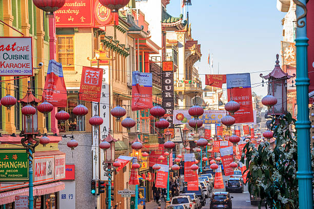 View of the main street of the chinatown district, traffic of cars and people in a cloudy day.